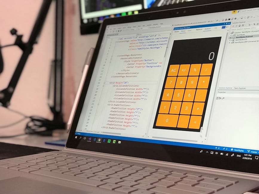 A close-up view of a laptop screen displaying lines of HTML code on the left, with a large, orange calculator interface on the right, showing basic arithmetic functions. The background reveals a blurr
